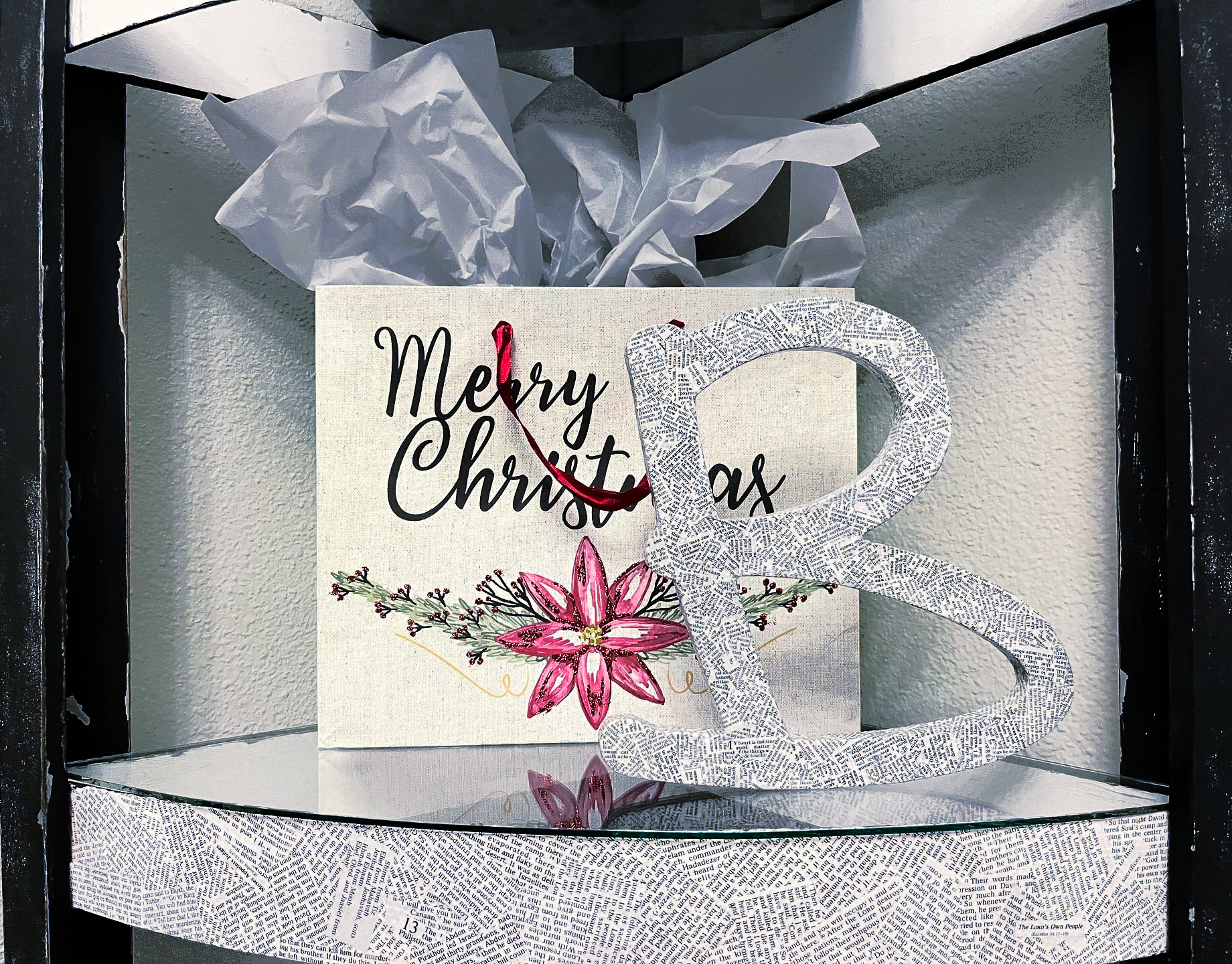 Elegant white gift box with glittery silver ribbon and a “Merry Christmas” card, accented by pink flowers.