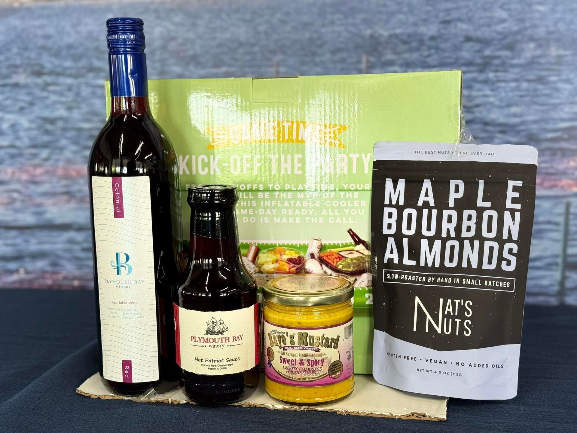 A gift box with red wine, dark sauce, mustard, and maple bourbon almonds.