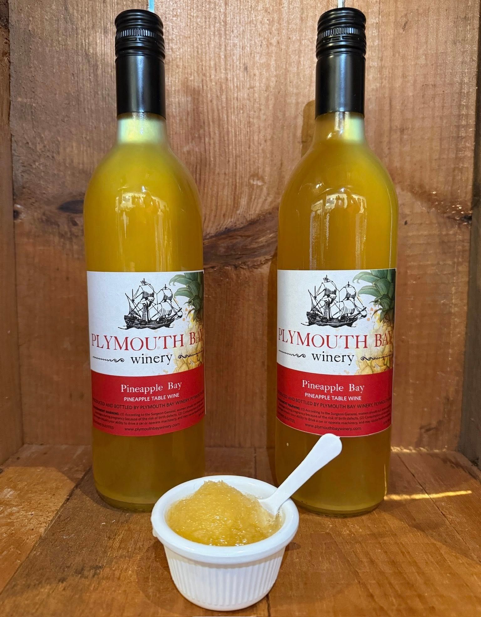 Two bottles of yellow liquid with a small dish of gold-colored granules in front.