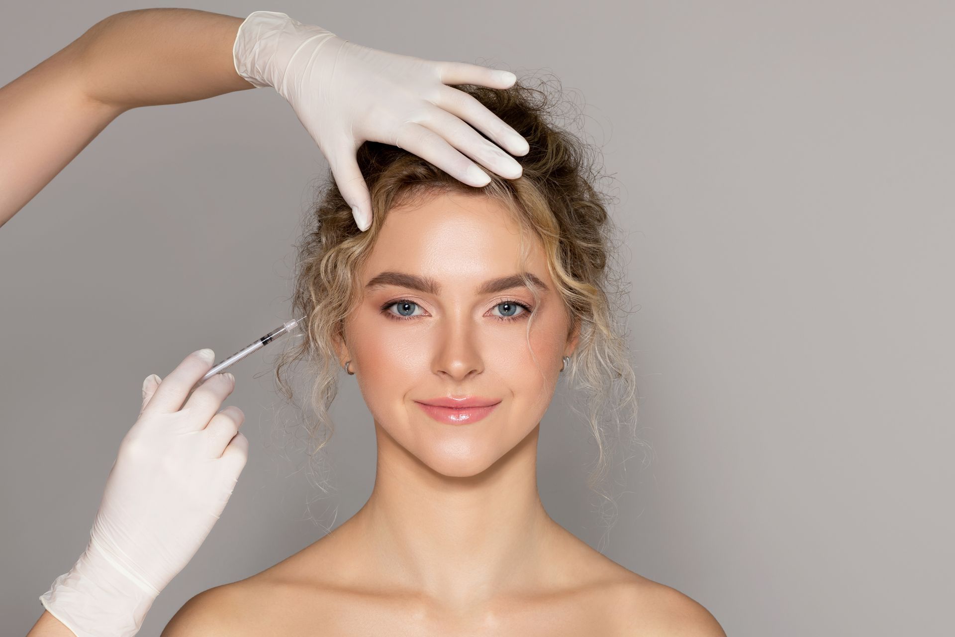 A woman is getting a botox injection in her face.