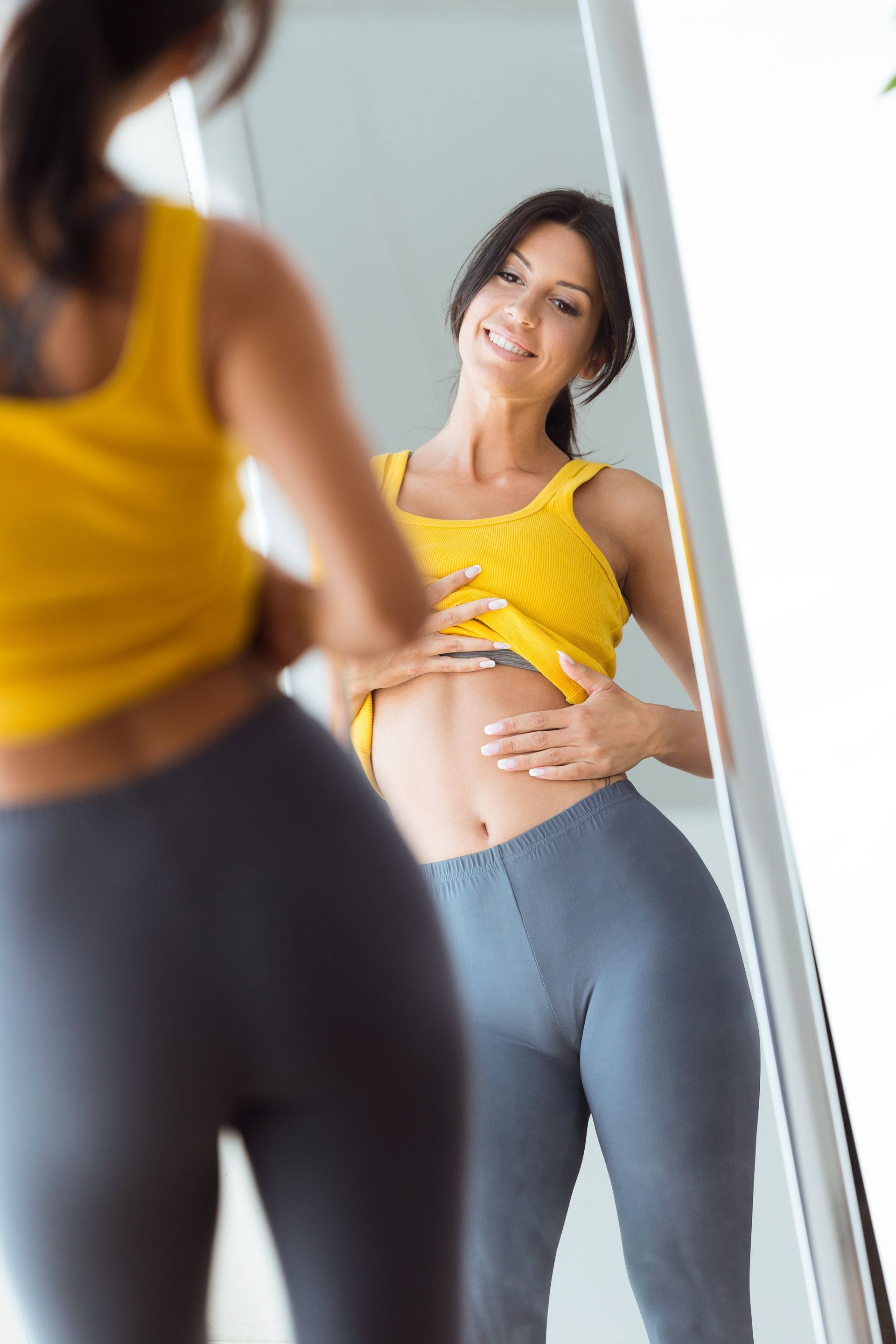 A woman is looking at herself in the mirror.