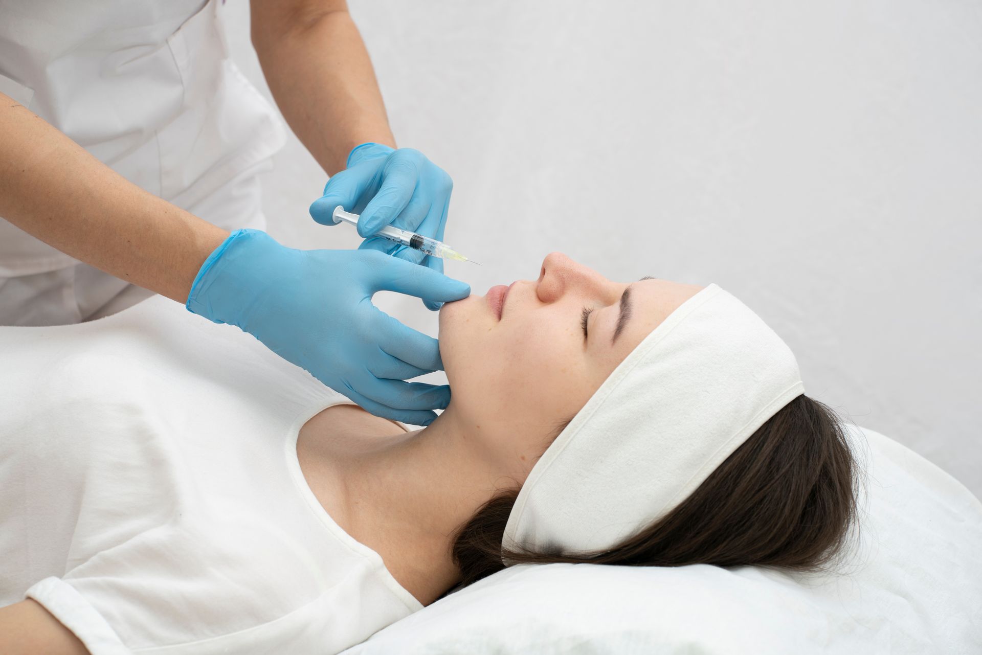 A woman is getting a botox injection in her face.
