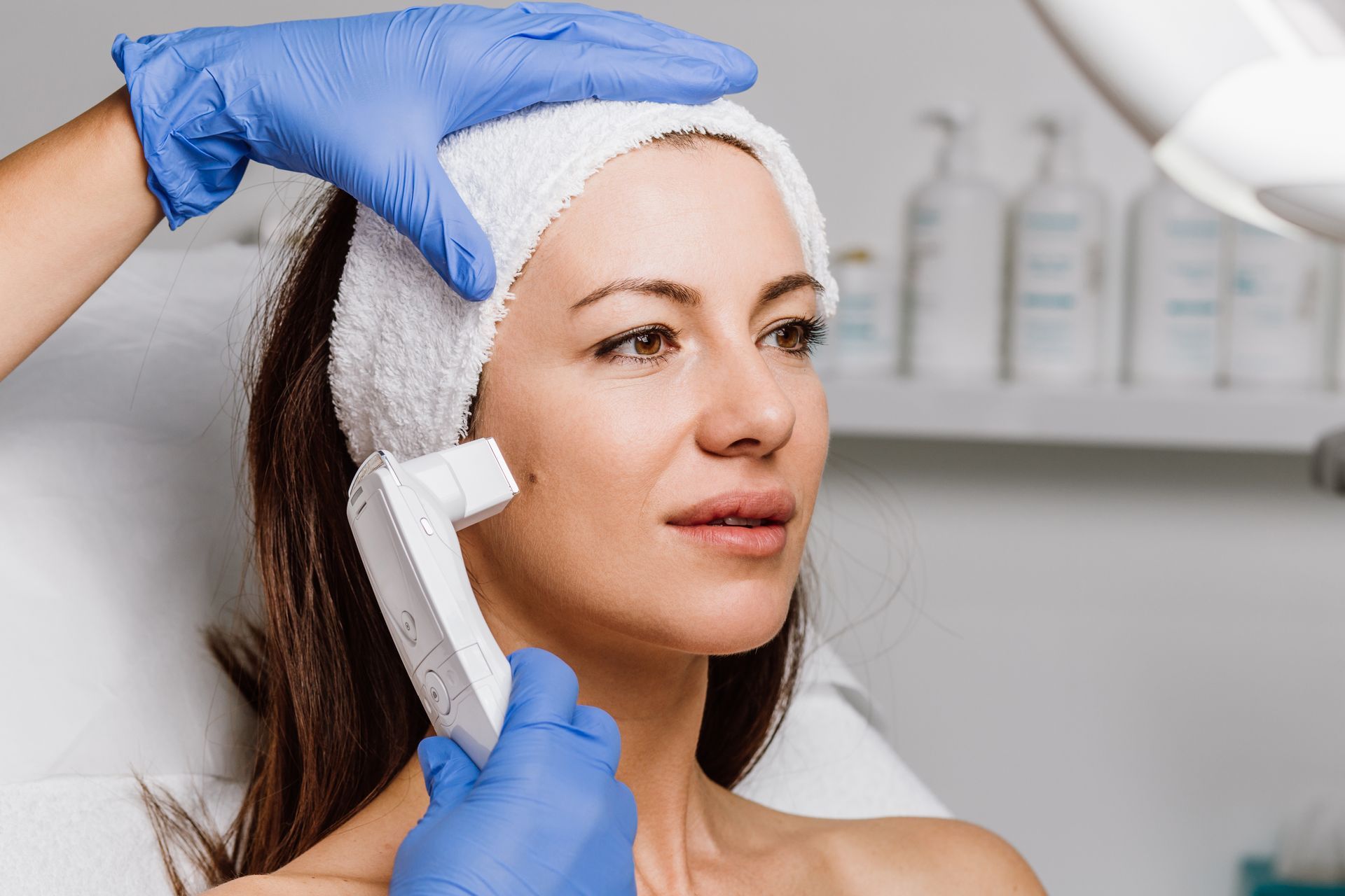 A woman is getting a facial treatment at a beauty salon.