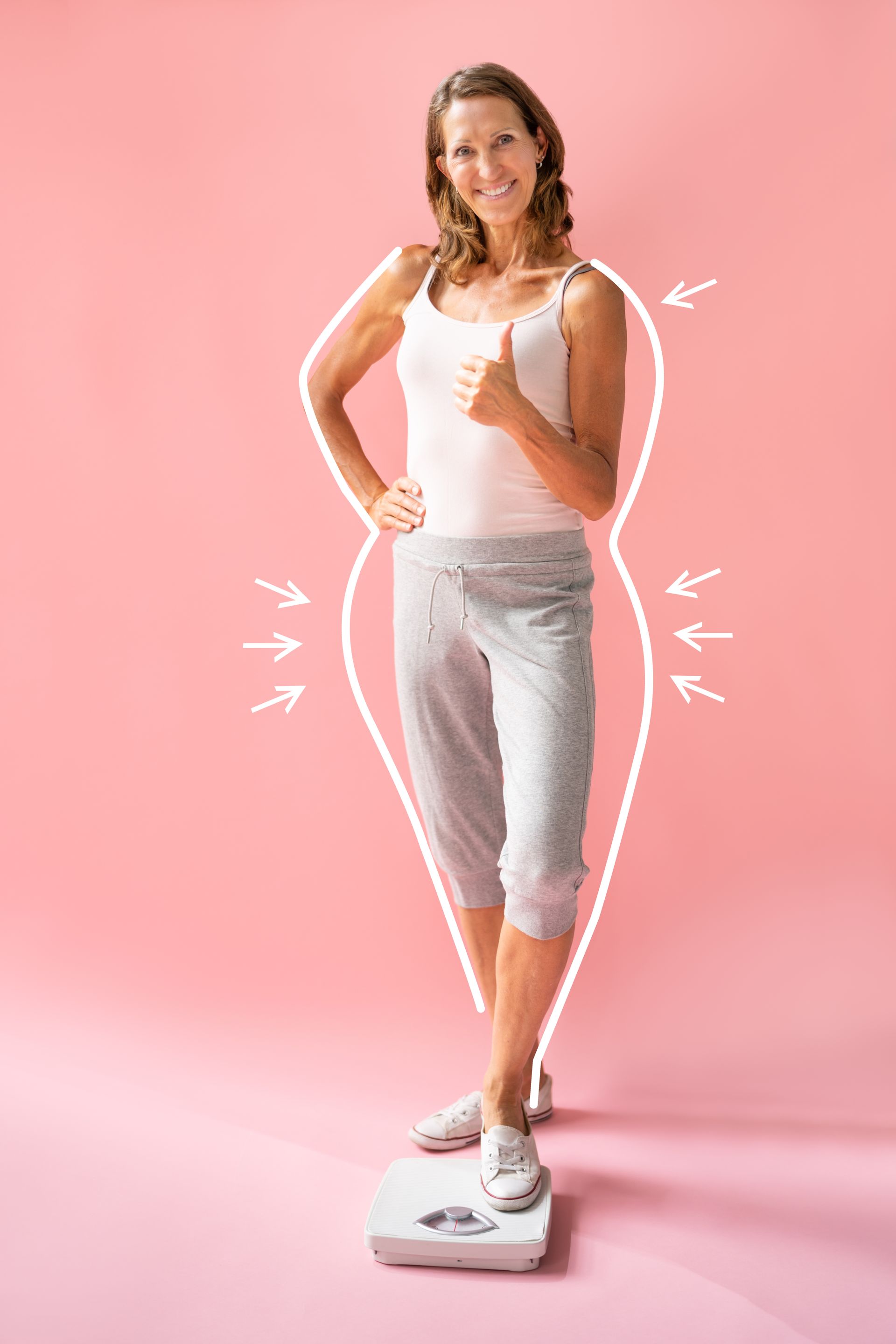 A woman is standing on a scale and giving a thumbs up.