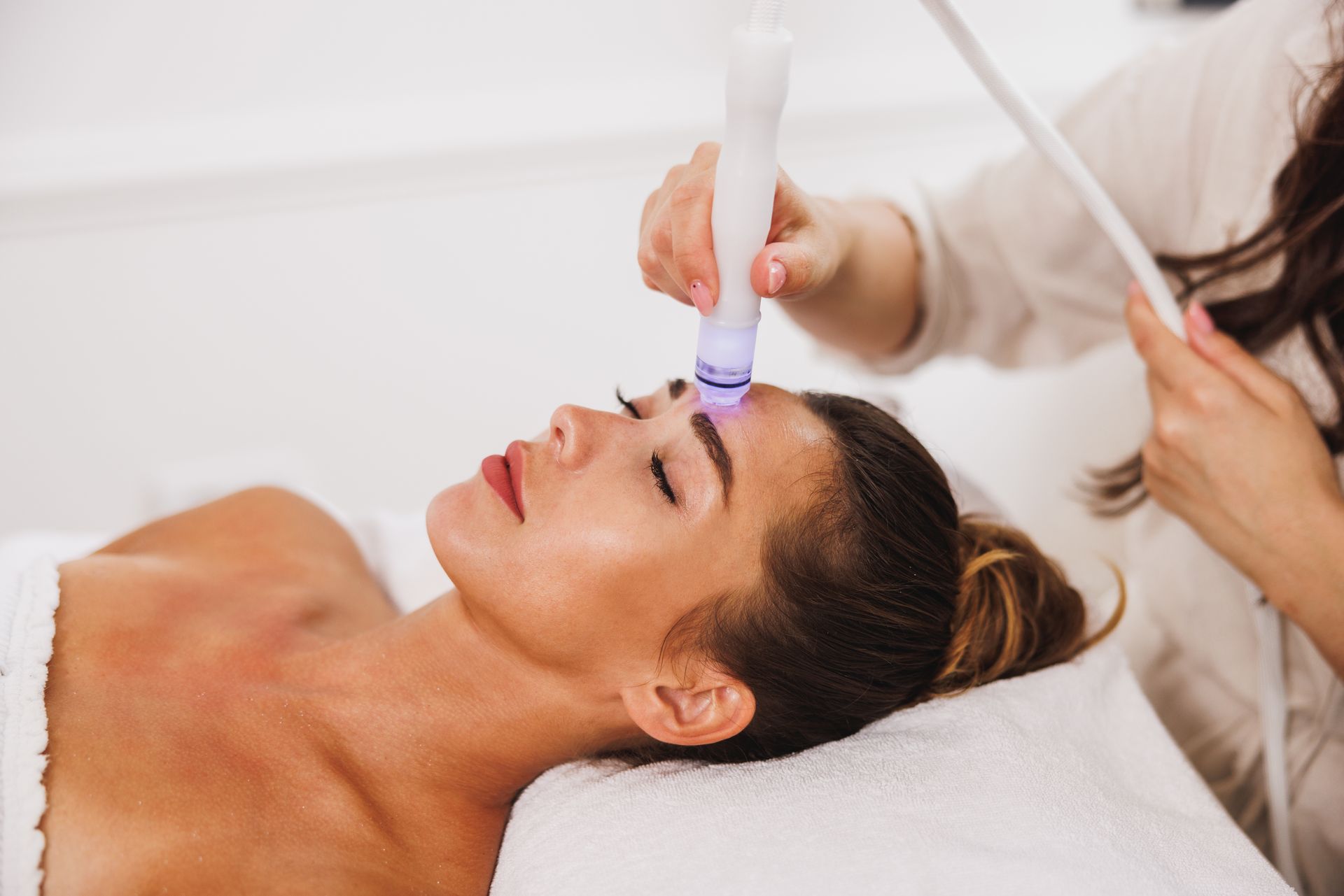 A woman is getting a facial treatment at a spa.
