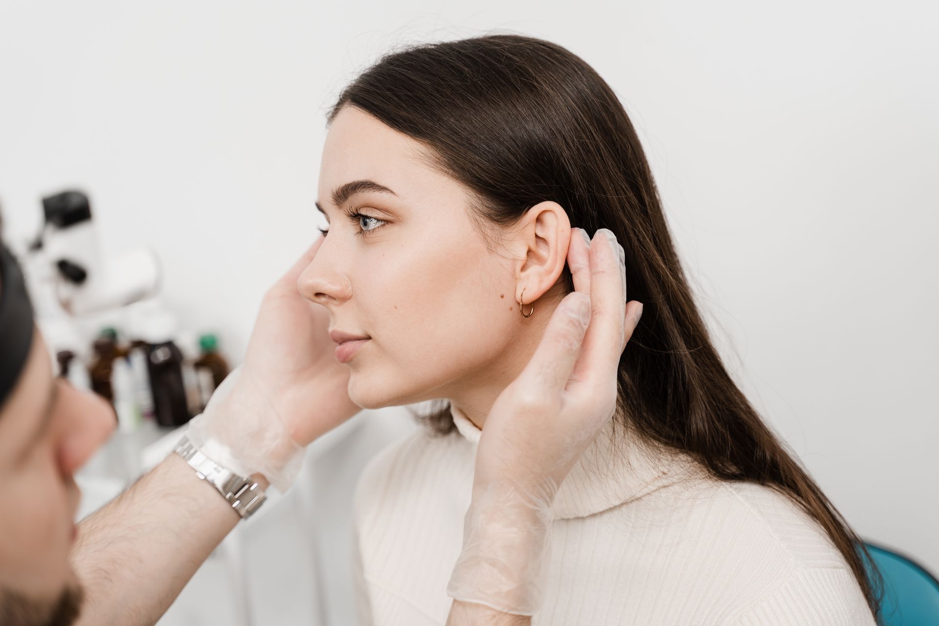 A woman is getting her ears examined by a doctor.