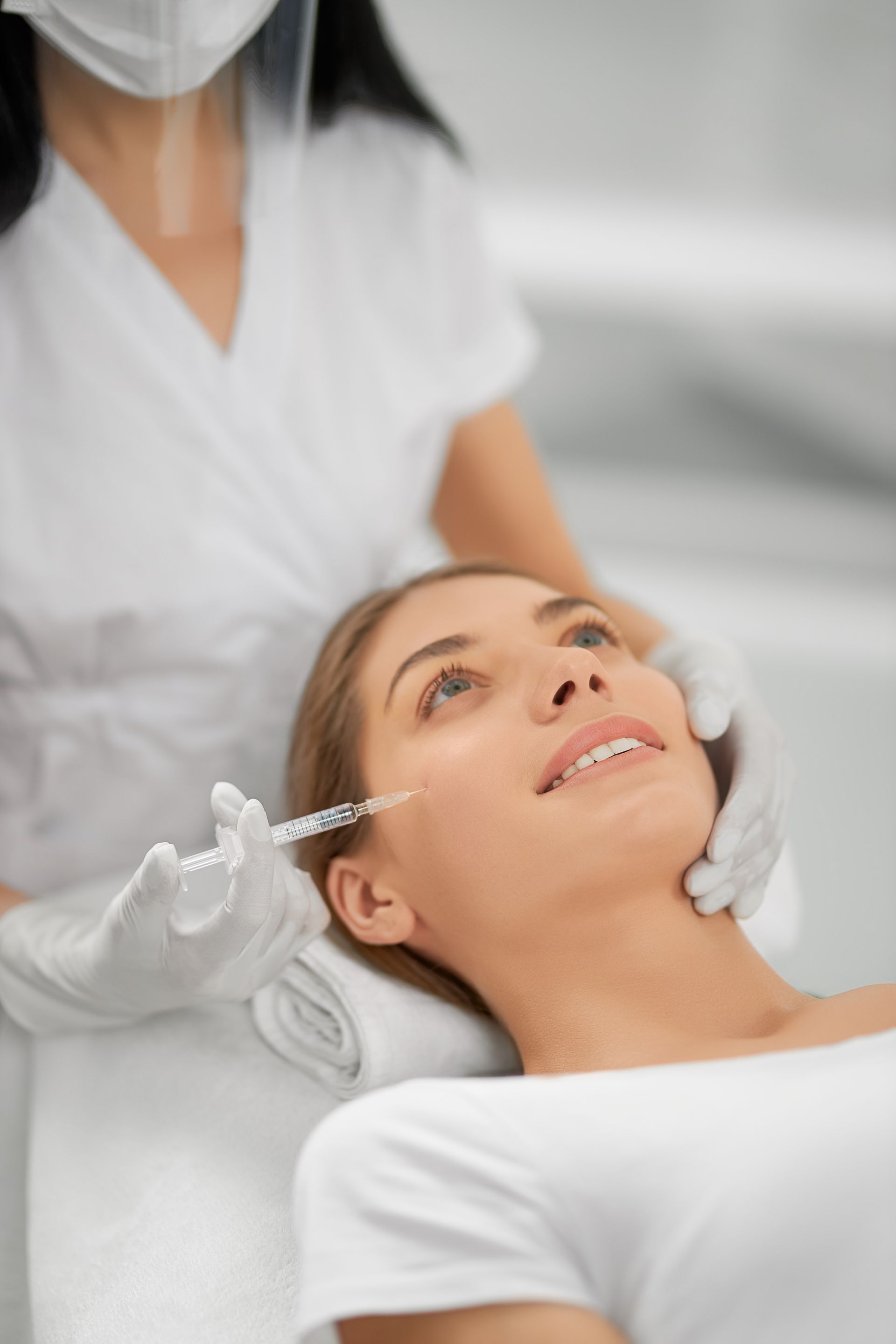 A woman is getting an injection in her face in a beauty salon.