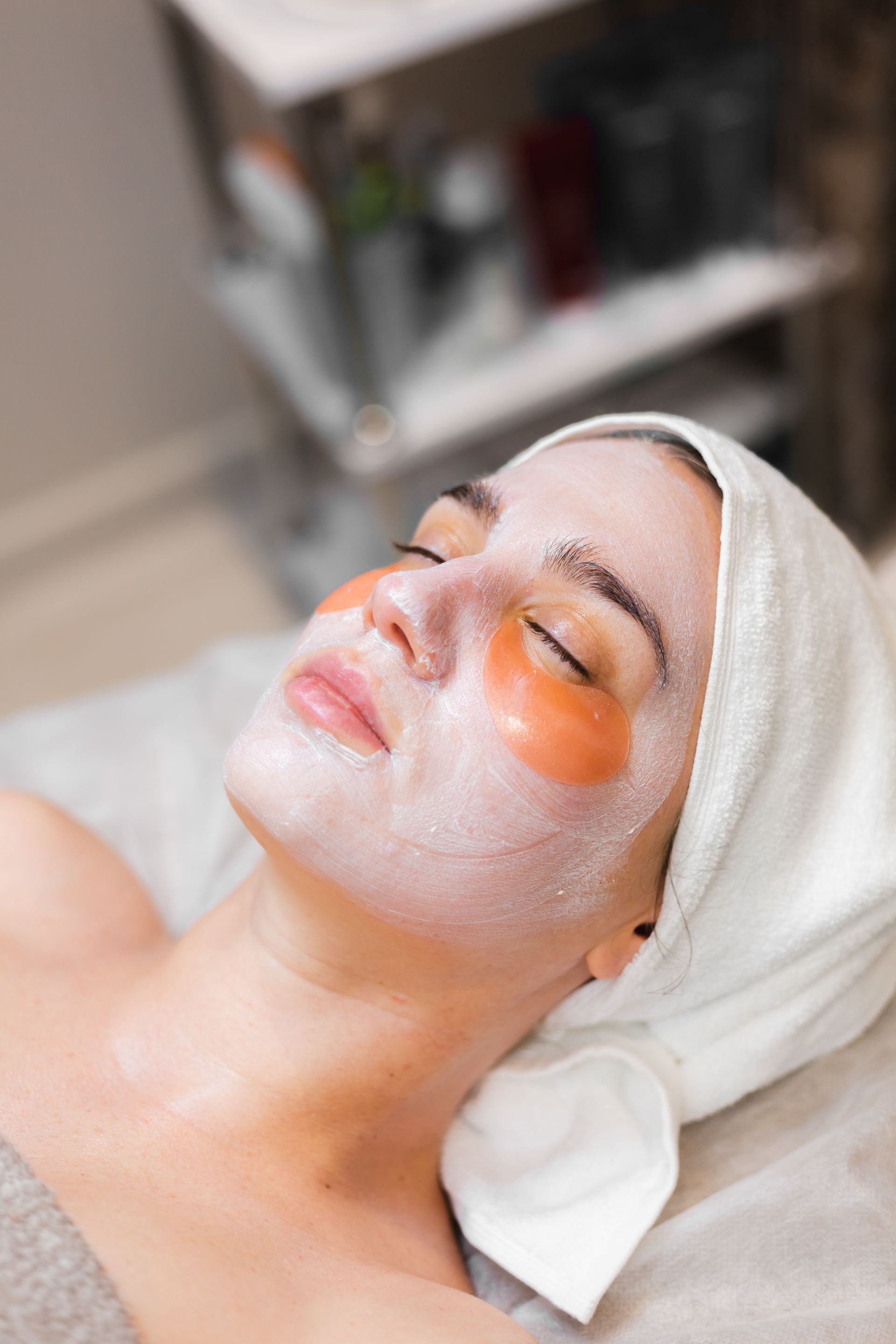 A woman is laying on a bed with a mask on her face.