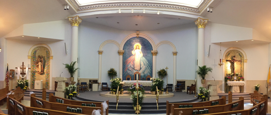 The inside of a church with a painting of jesus on the altar.