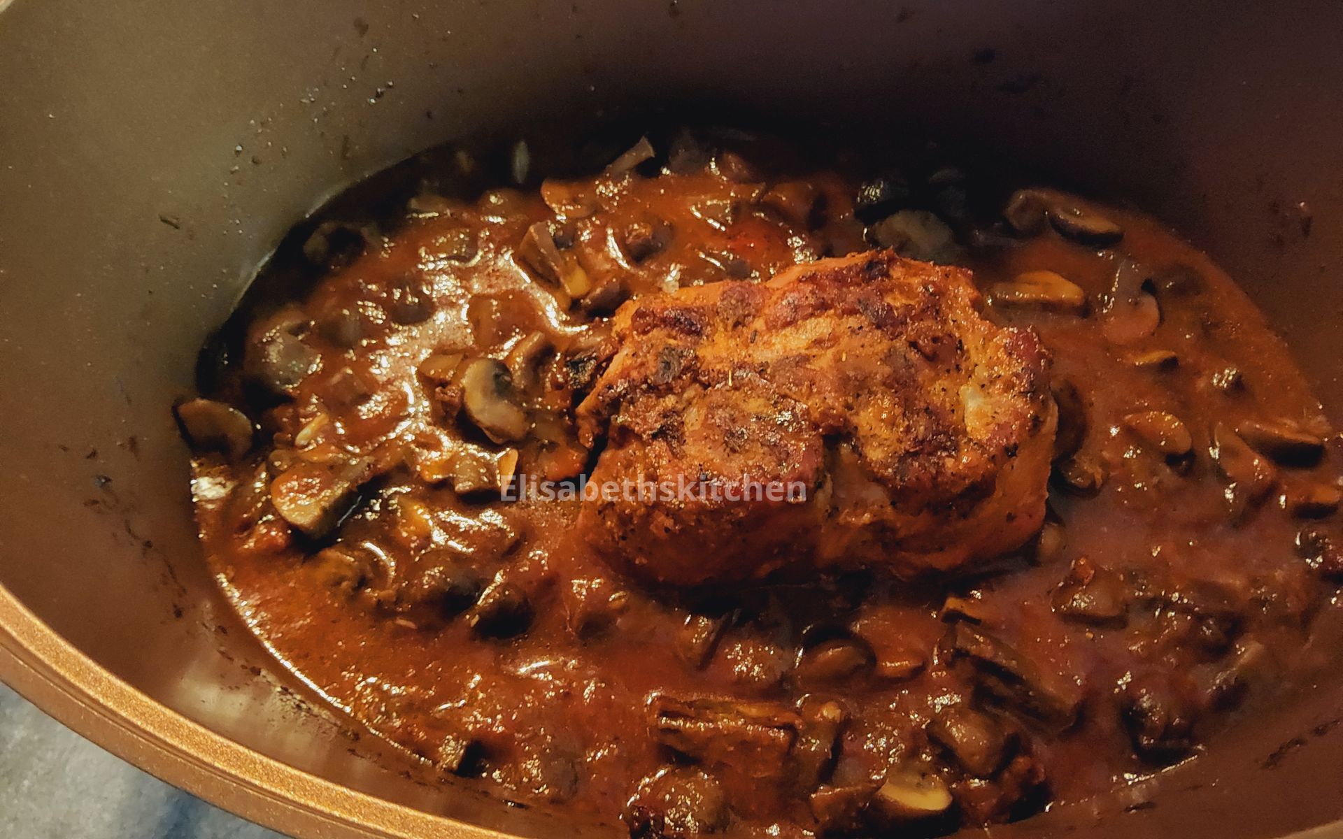 Bak het vlees bruin in een pan met champignons en saus.