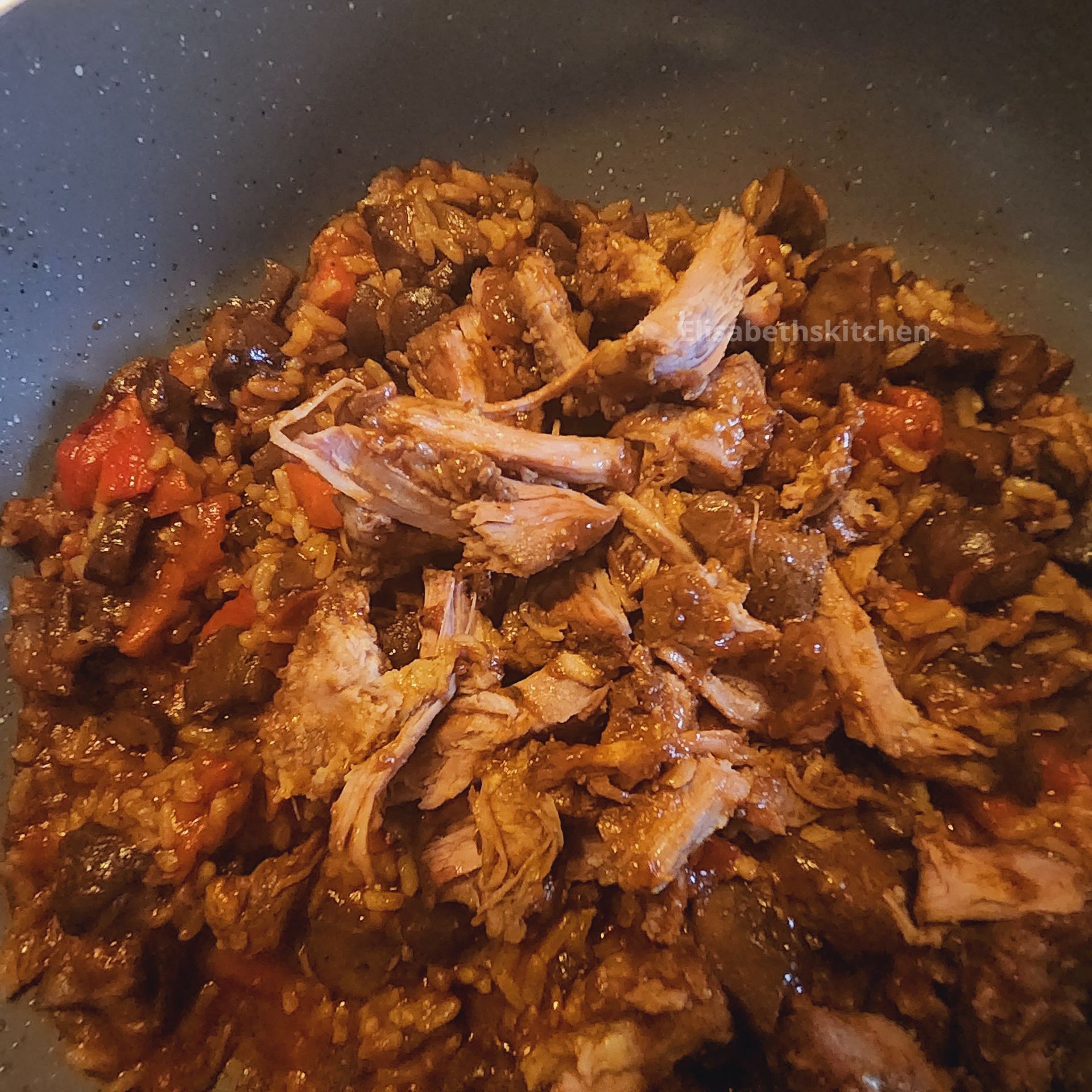 Gesneden vlees met groenten en saus in een pan.