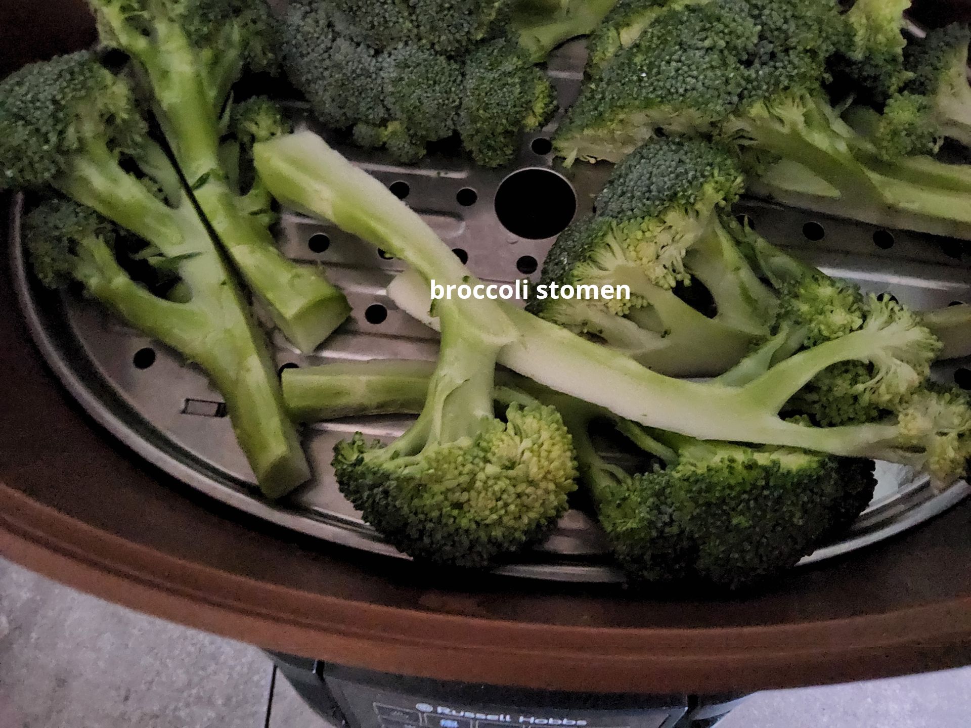 Broccoliroosjes en -stelen in een bruine stoommand.