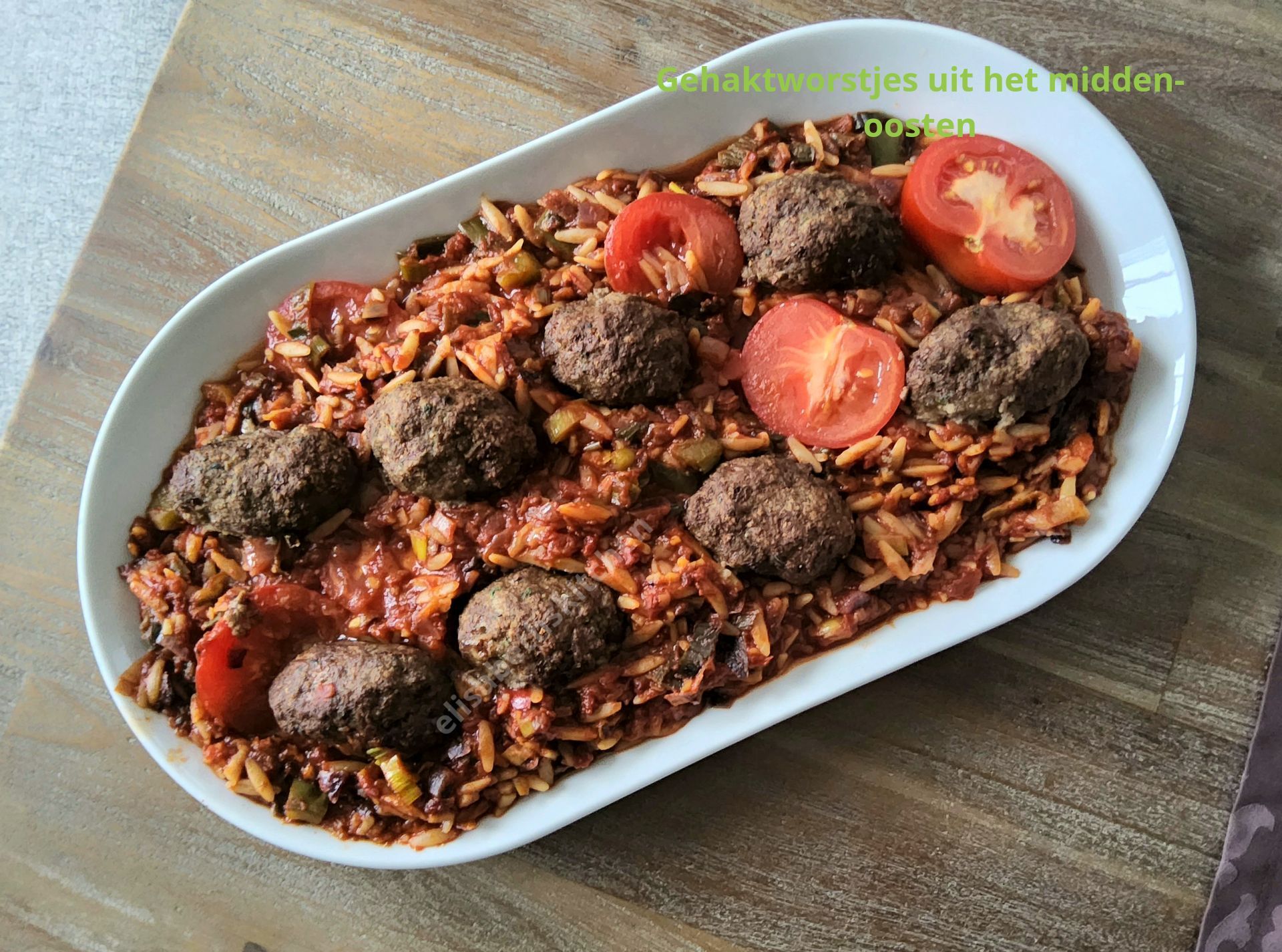 Ovale schotel met Midden-Oosterse gerechten: rijst met gehaktballetjes en tomatenschijfjes.