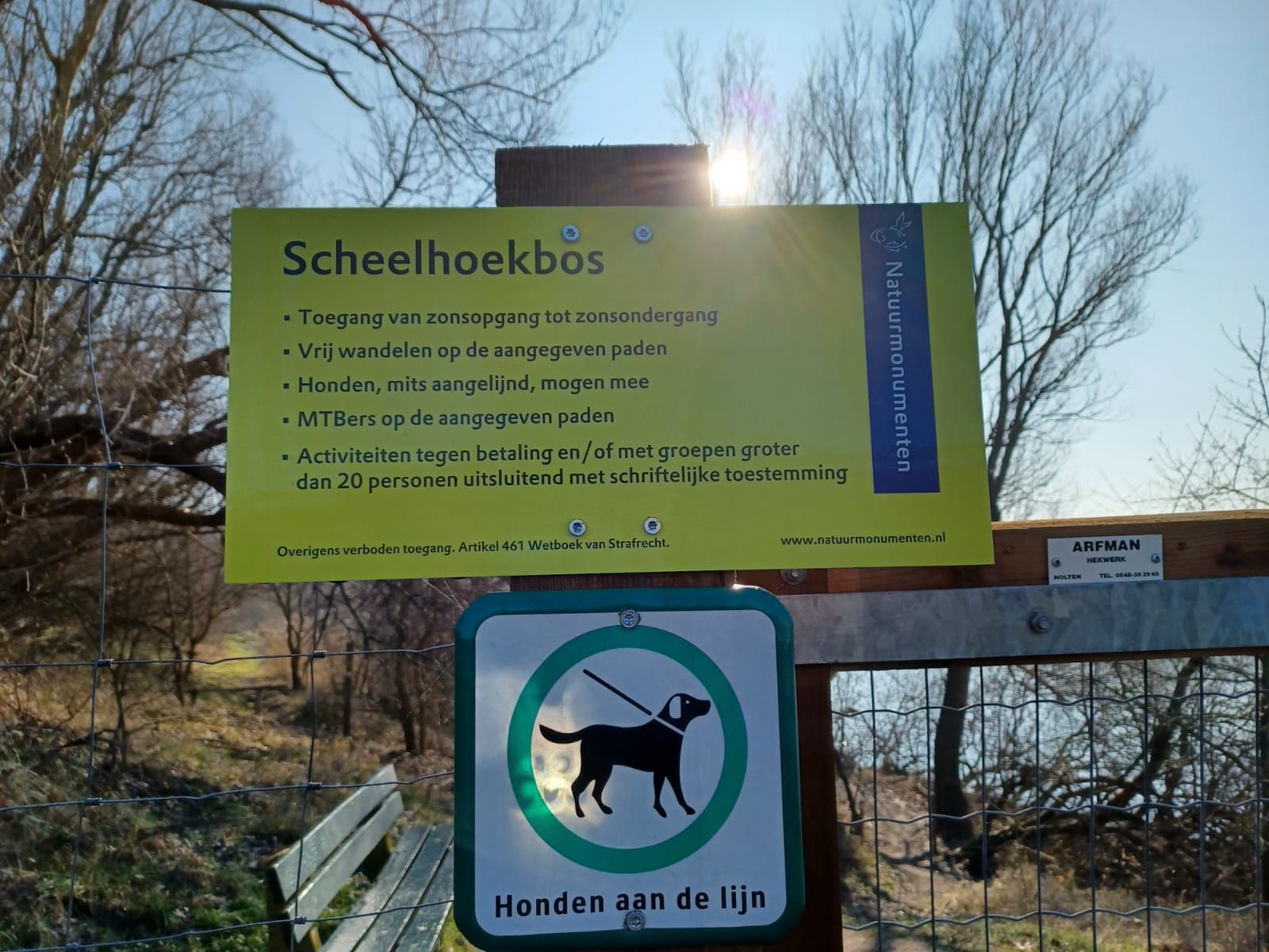 Sign for Scheelhoekbos, yellow with text and a dog-leash symbol. 