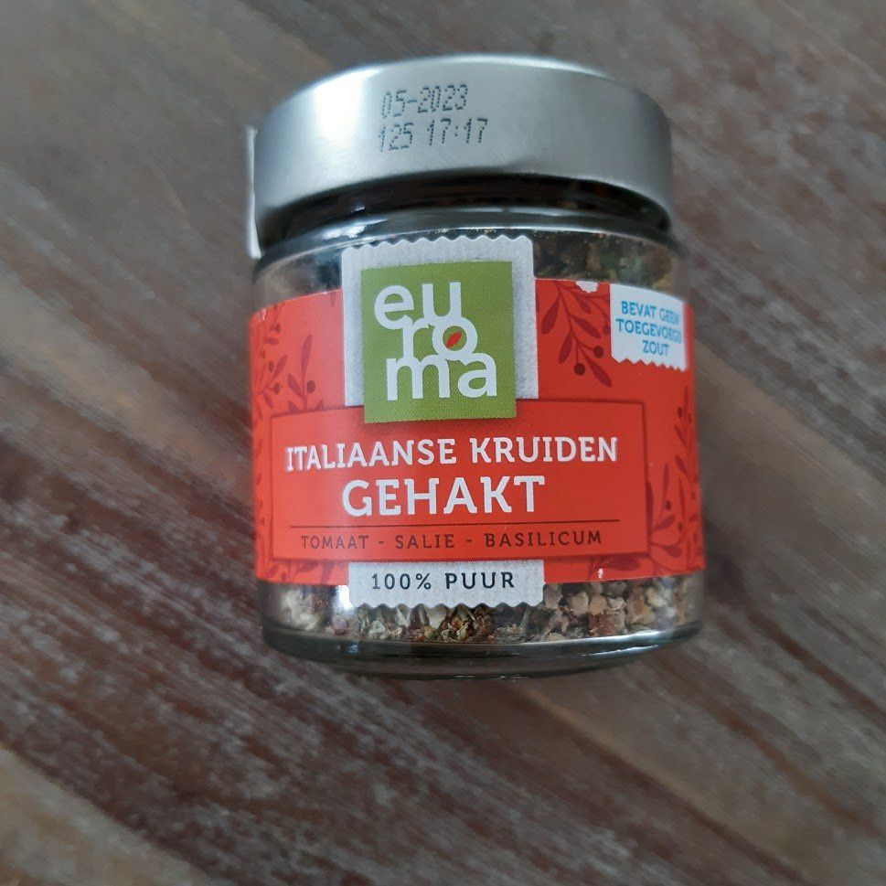 verderop staat het recept Pot met Italiaanse kruiden van Euroma, waarin de fijngesneden kruiden zichtbaar zijn, tegen een houten ondergrond.