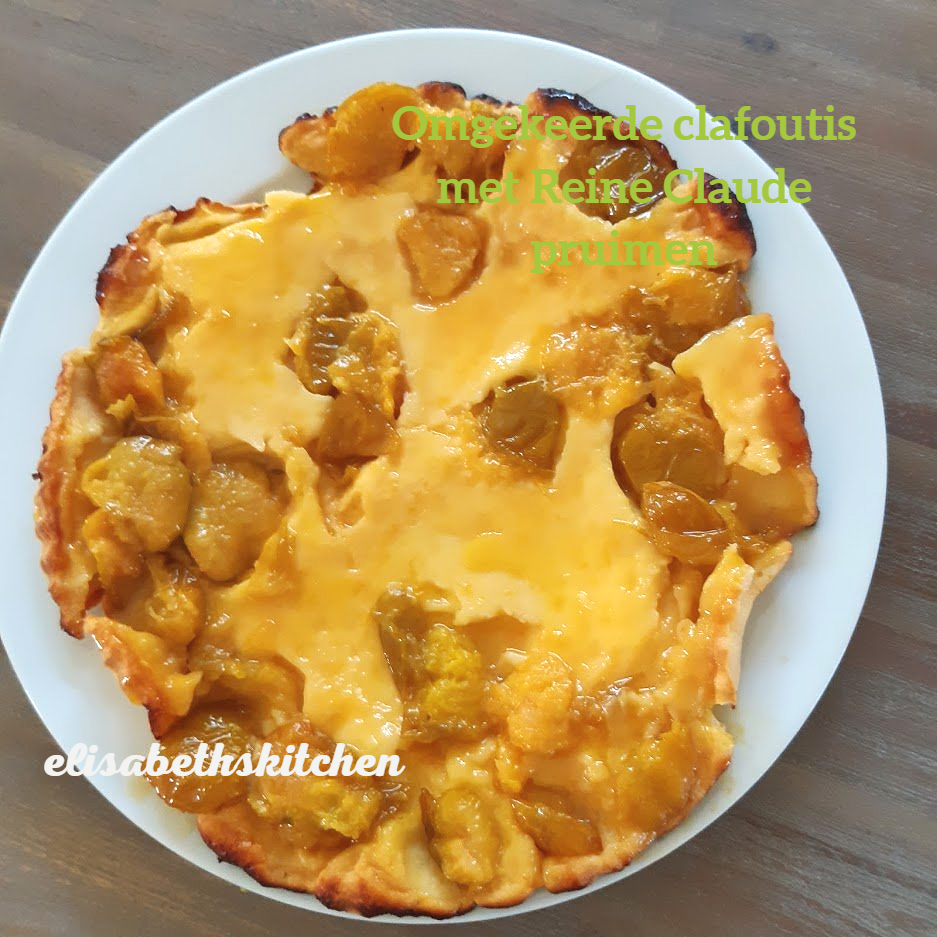 Clafoutis, een dessert met goudgele pruimen, geserveerd op een wit bord.