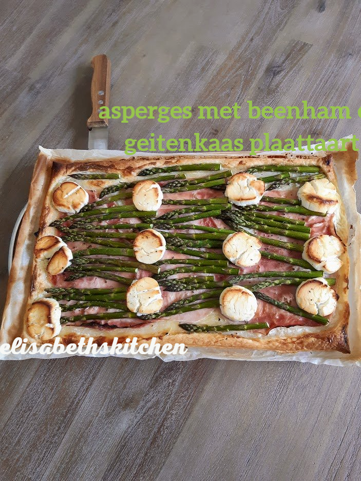 Asperge- en geitenkaastaart, gebakken op een rechthoekige deegbodem, met een mes.