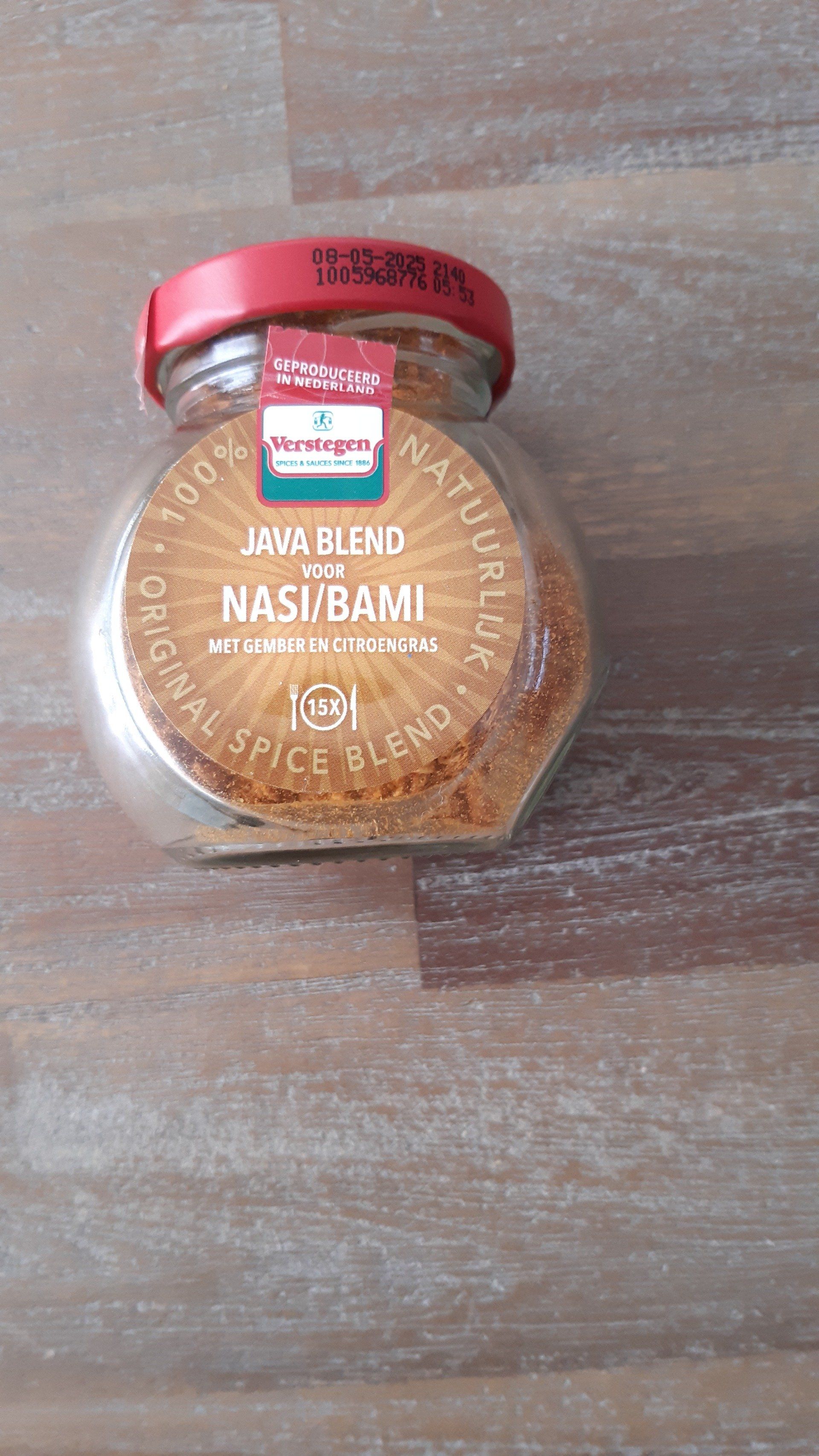 Glazen pot met Nasi Bami kruidenmengsel, met een rood deksel, op een houten ondergrond.