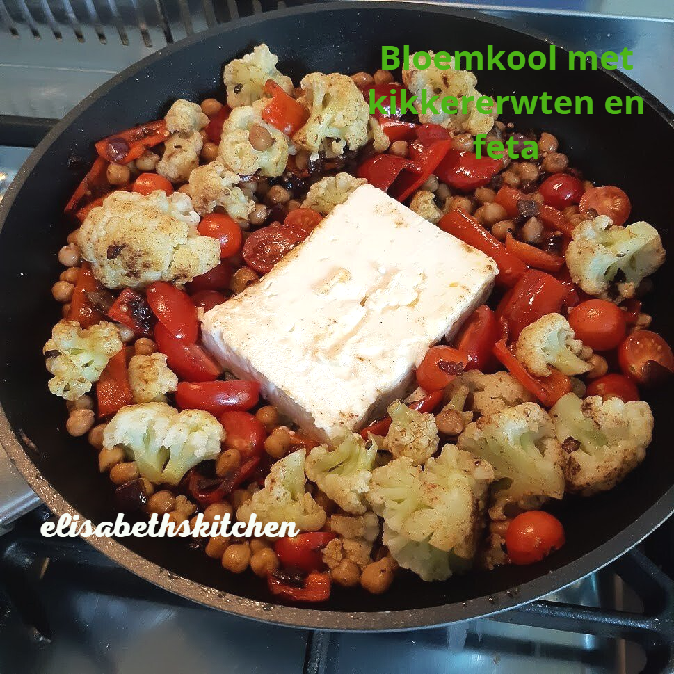 Geroosterde bloemkool, kikkererwten en rode paprika met feta in een pan.
