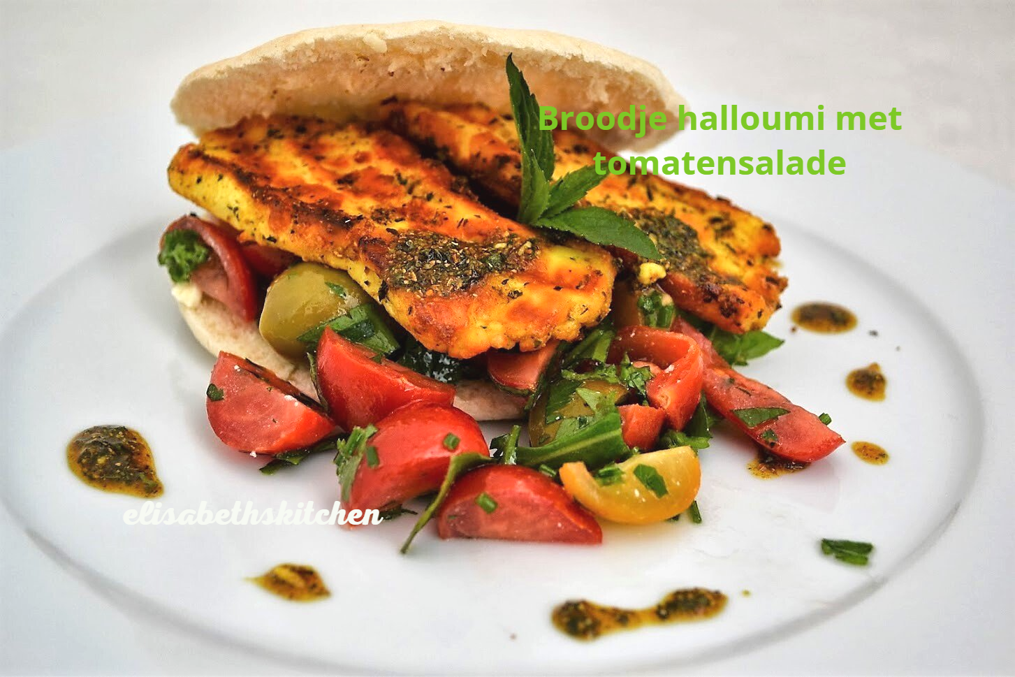 Halloumi-sandwich met tomatensalade op een bord. Gesneden tomaten, kruiden en dressing.