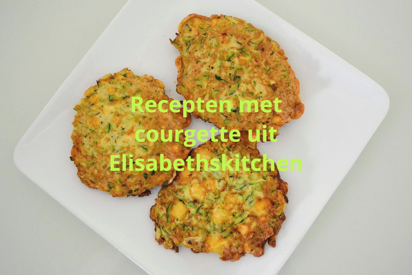 Drie goudbruine courgettebeignets op een wit vierkant bord, met de tekst