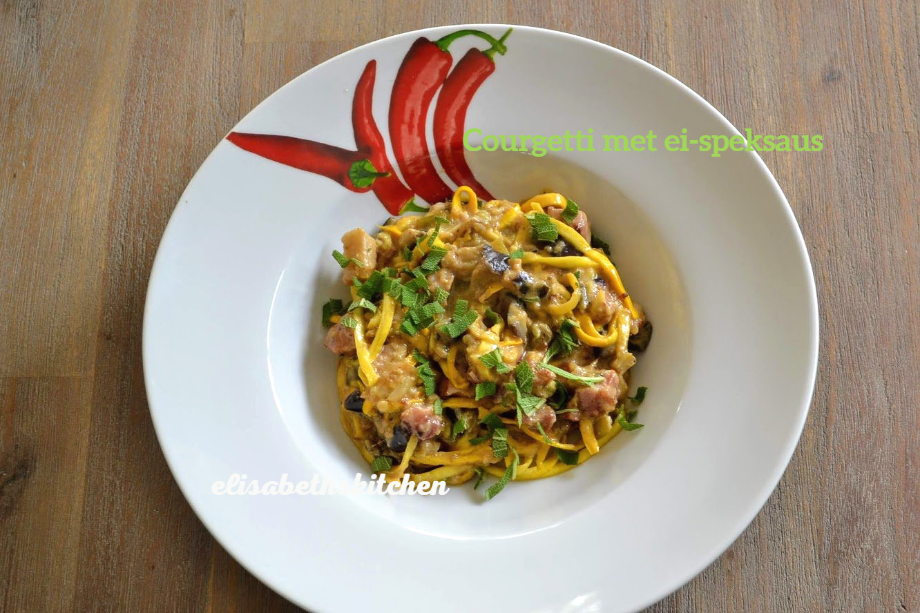 Pastagerecht met gele saus en groene kruiden op een wit bord met chilipepermotief.