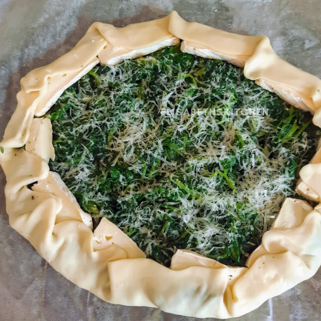 Spinazie- en kaasgalette, ongebakken, met gevouwen korst.