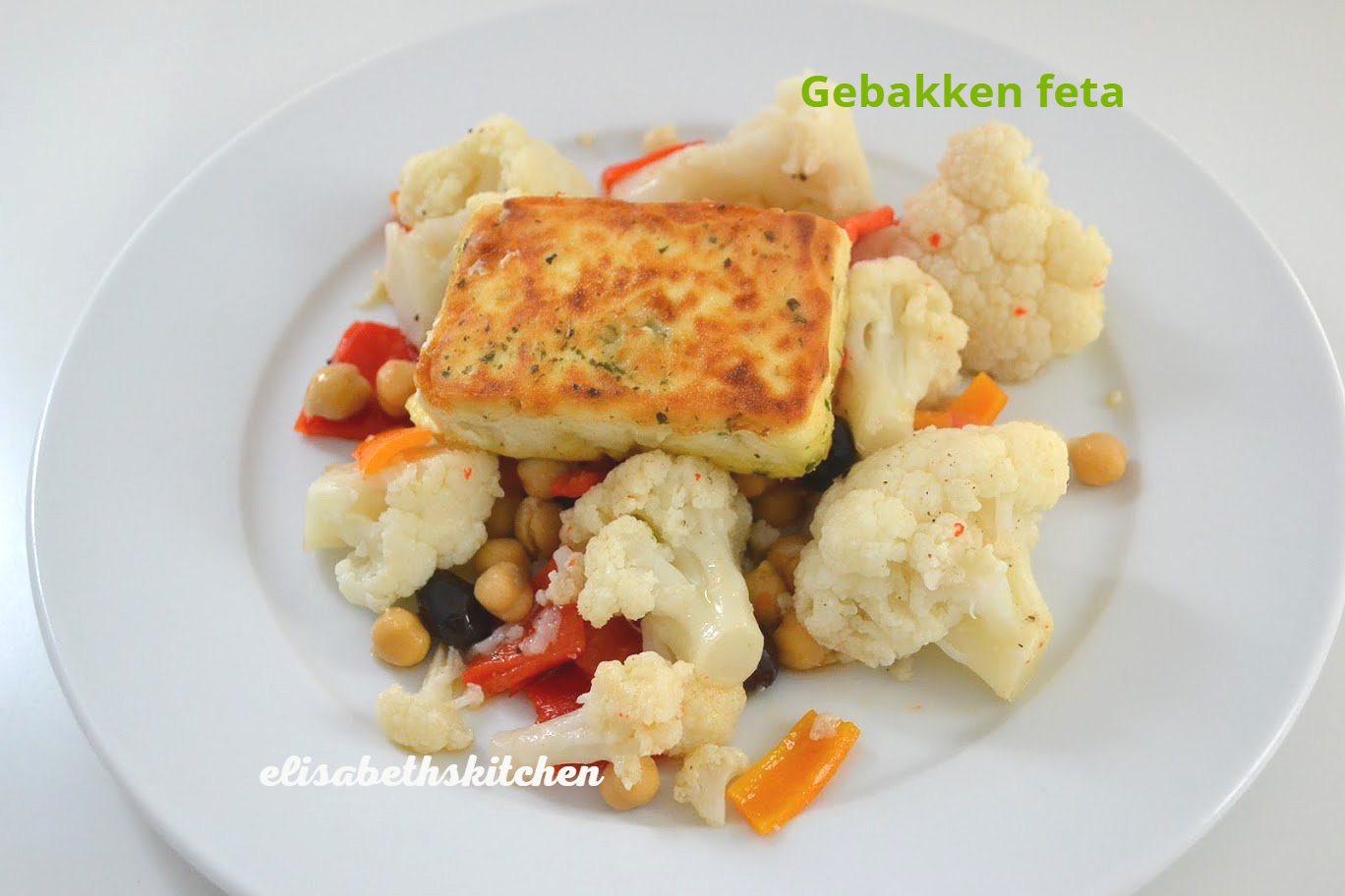 Bord met gebakken feta, bloemkoolroosjes, kikkererwten en paprika.