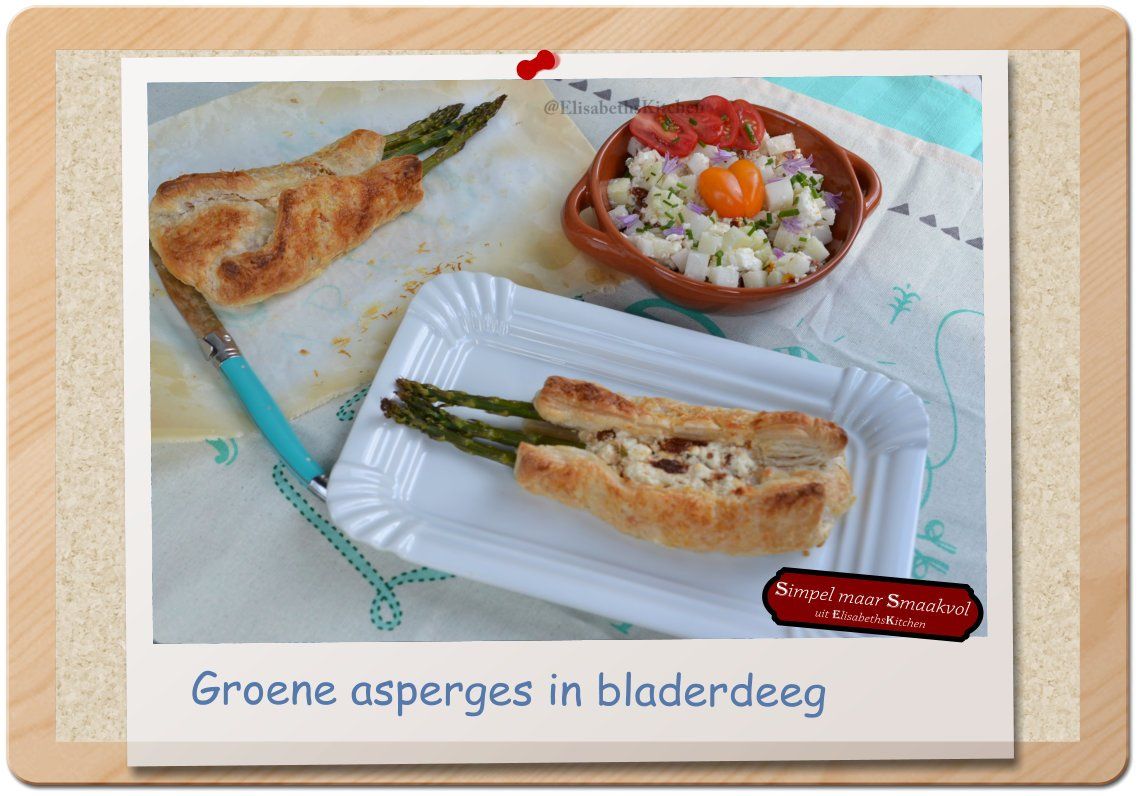 Groene asperges in bladerdeeg op een wit bord, met een bijgerecht op tafel.