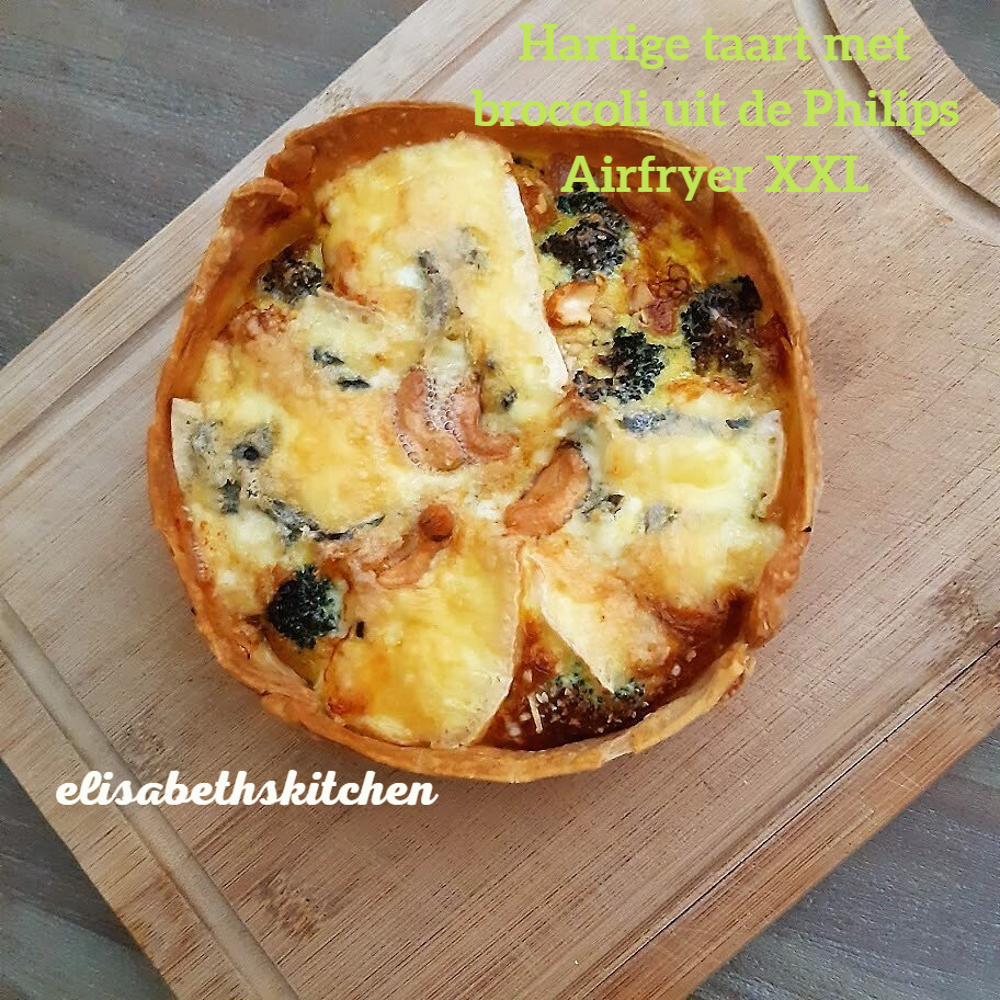 Quiche met broccoli uit een Philips Airfryer. Een goudbruine taart op een houten snijplank.