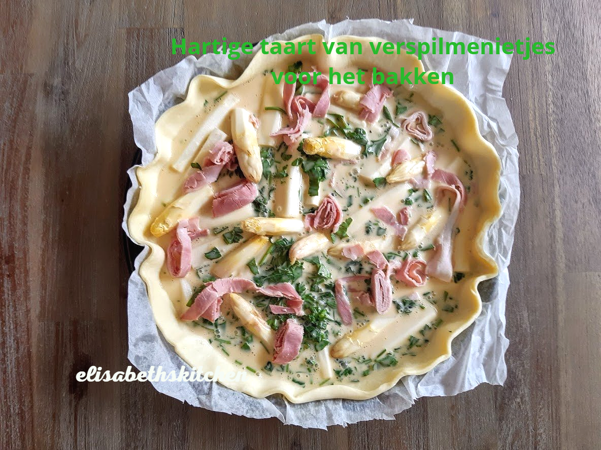Quiche met asperges en ham, voor het bakken, op bakpapier.