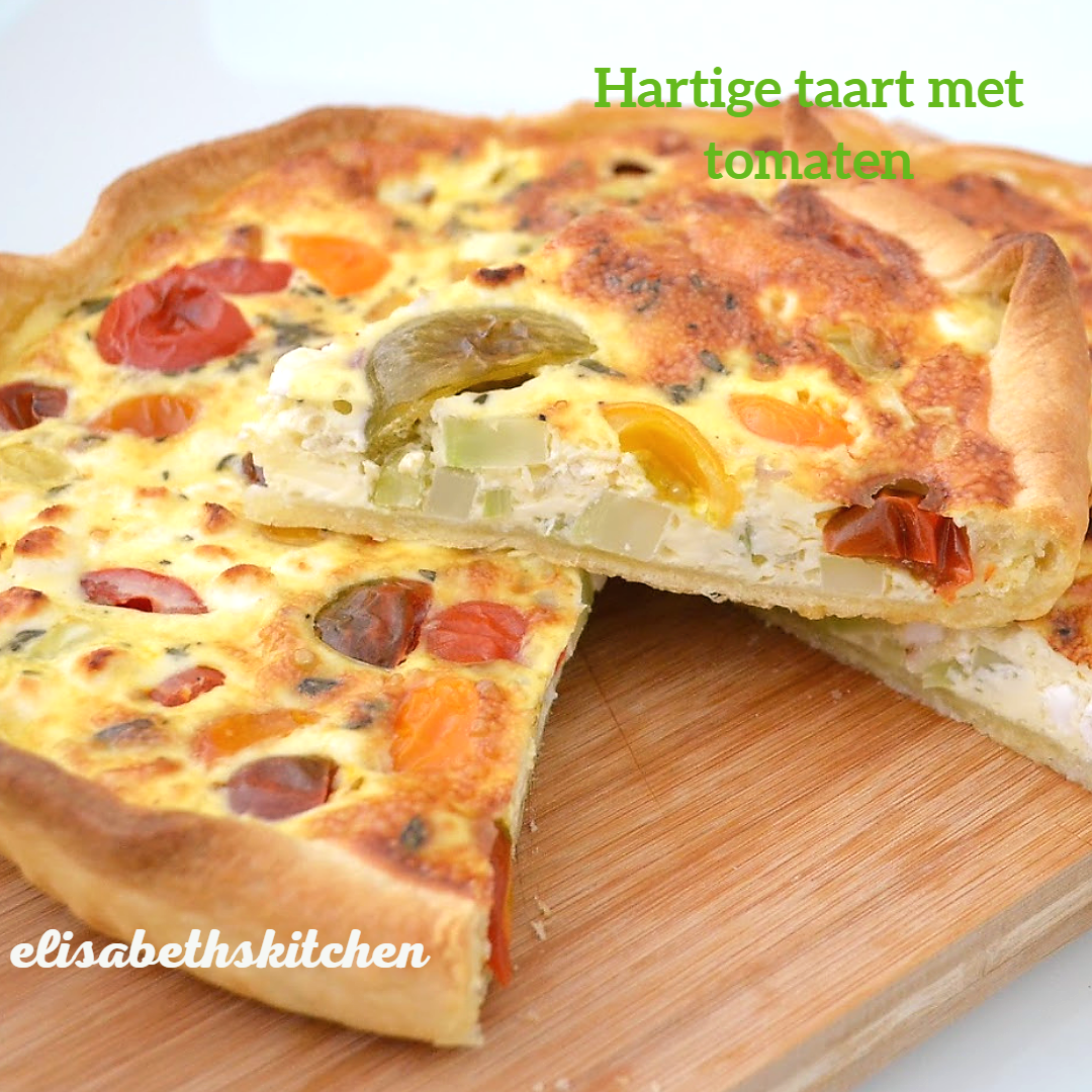 Tomatentaart, in plakken gesneden, op een houten plank. Kleurrijke tomaten worden in de quiche gebakken.