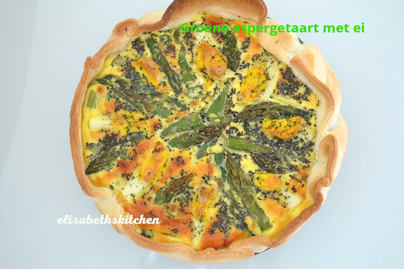 Aspergequiche met eieren en maanzaad in een goudbruine korst.