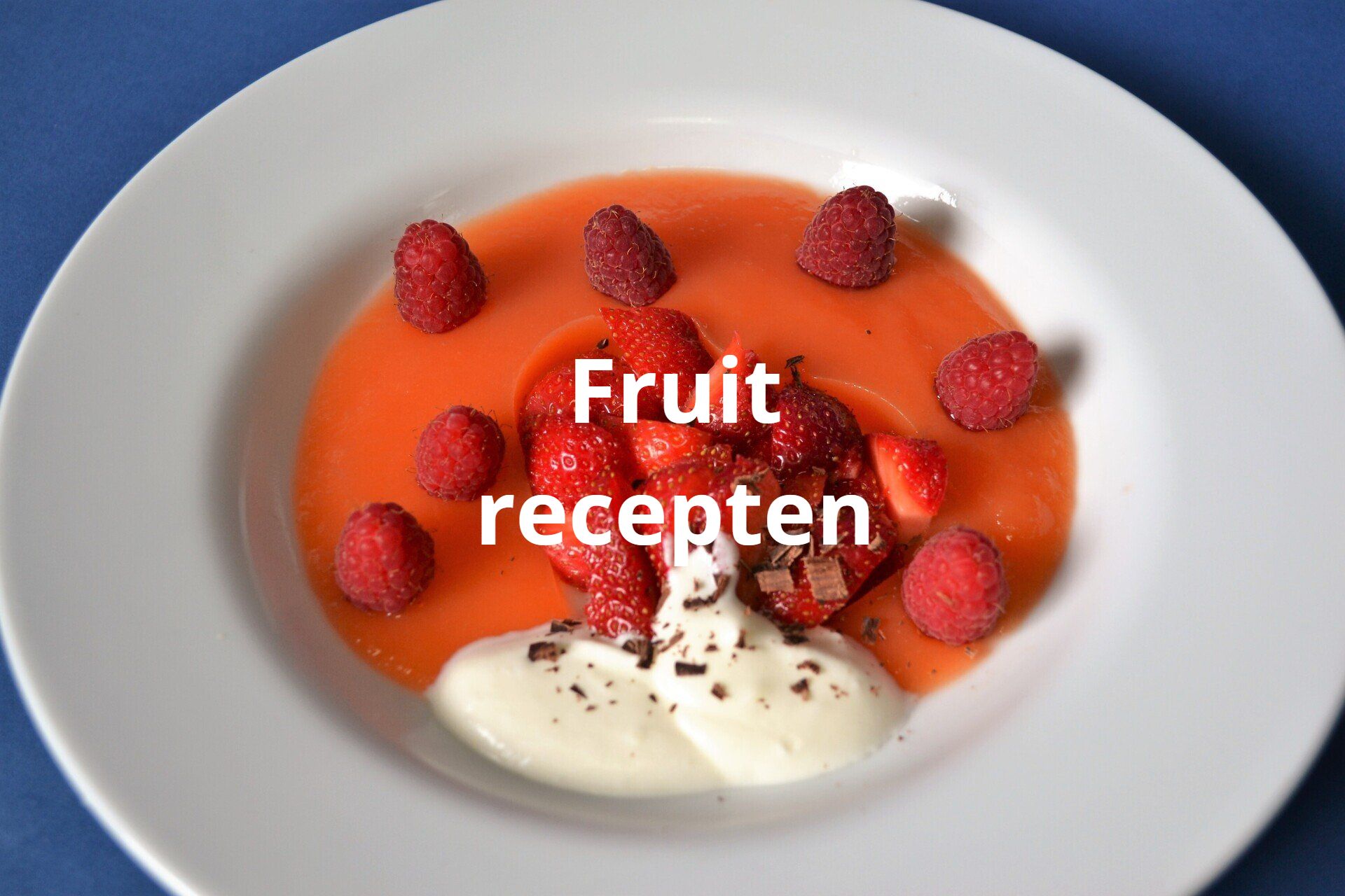 Dessert met frambozen, aardbeien en slagroom in een saus op een wit bord. De tekst luidt: 