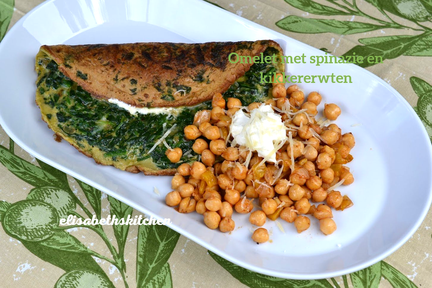 Omelet met spinazie en kikkererwten op een wit bord; groene, bruine en gele ingrediënten; opname van bovenaf.