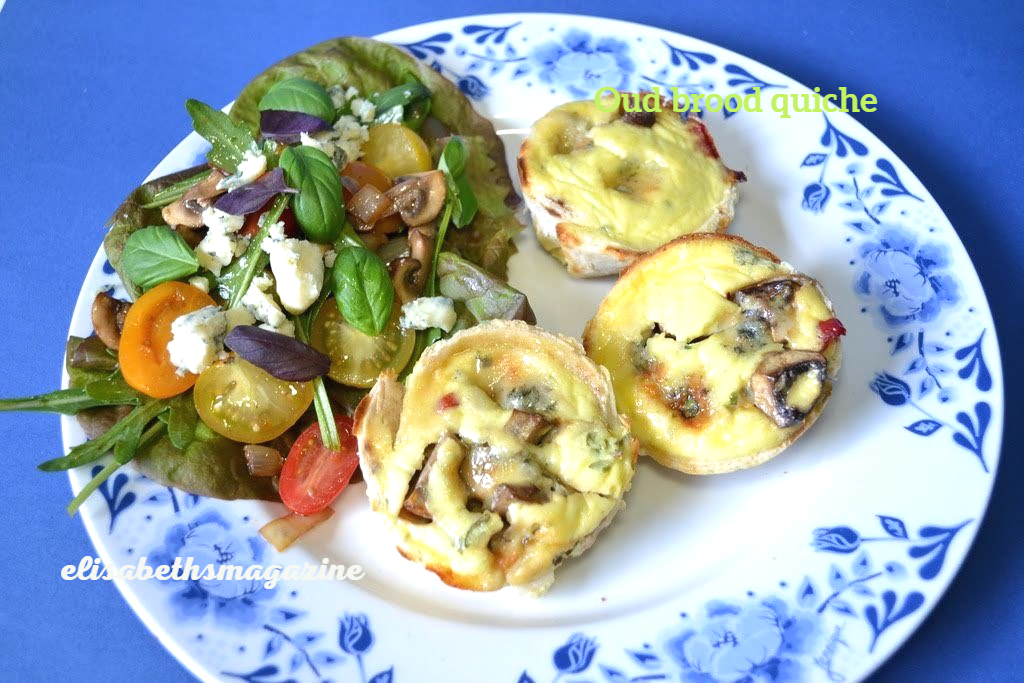 Mini-quiches en salade op een blauw bord met bloemenmotief.