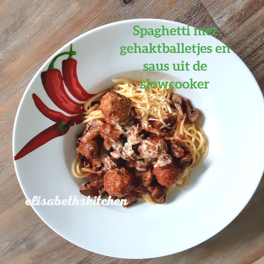 Spaghetti met gehaktballetjes en saus in een witte kom met rode chilipepers.