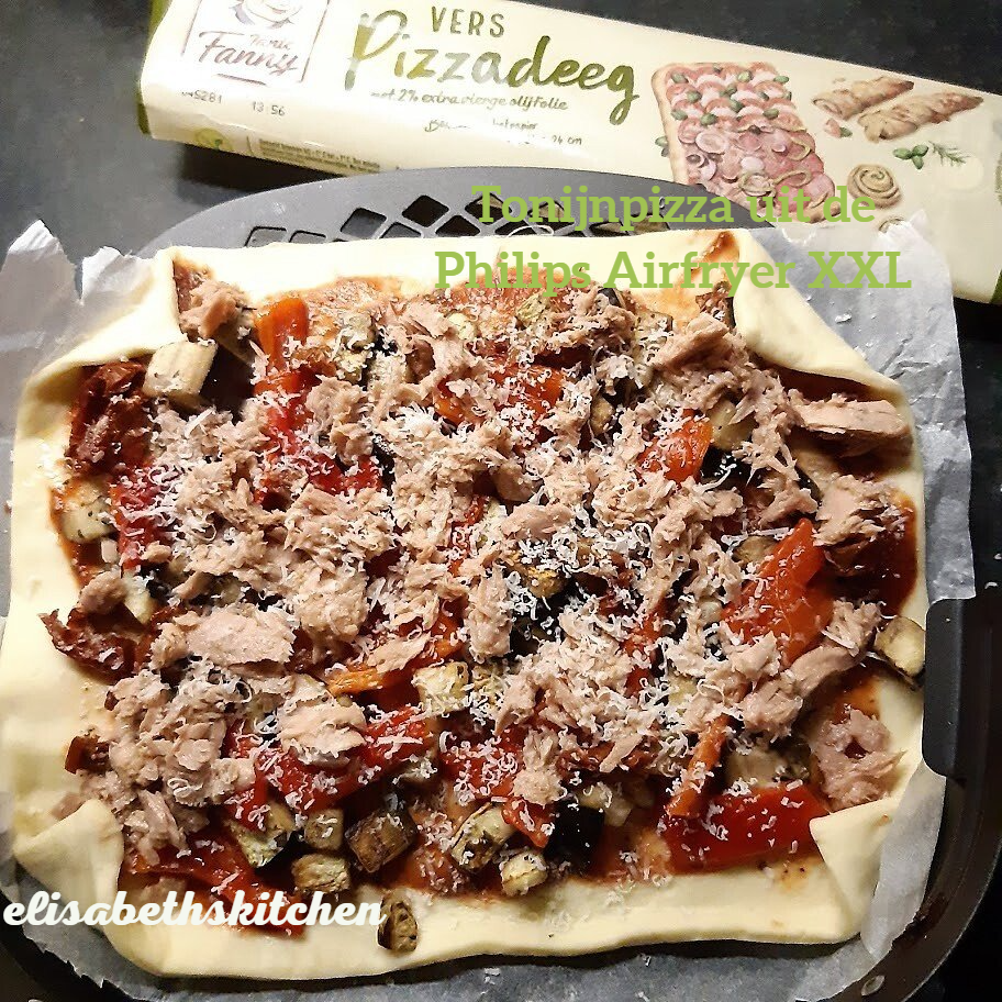 Pizzadeeg met toppings, waaronder tonijn, tomaten en kaas, bereid in de airfryer.
