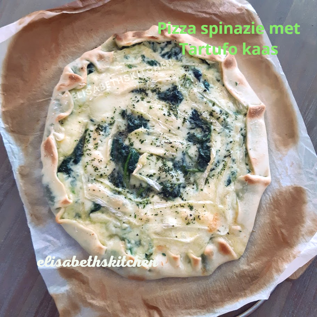 Spinaziepizza met truffelkaas op bakpapier, rustieke stijl.