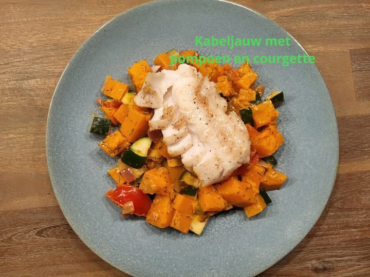 Kabeljauw met pompoen en courgette op een blauw bord.