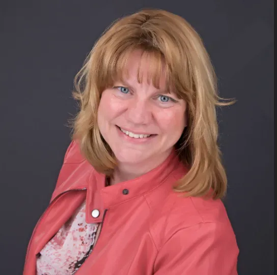 A woman wearing a red leather jacket is smiling for the camera.