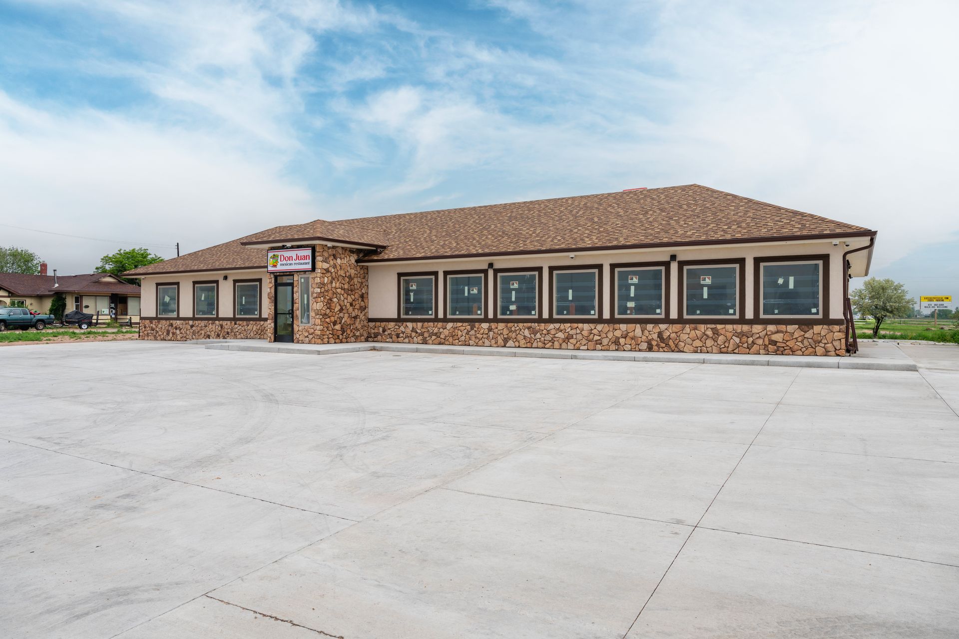 A single-story building with a brown roof and stone veneer siding, likely a restaurant.