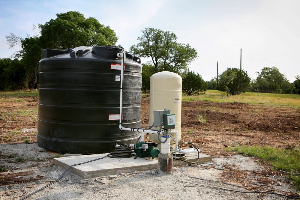 A Water Pump is Sitting Next to a Water Tank in a Field — Elite Water In Kyogle, NSW