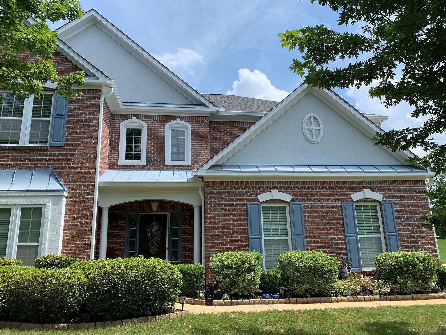 A large brick house with white trim and blue shutters