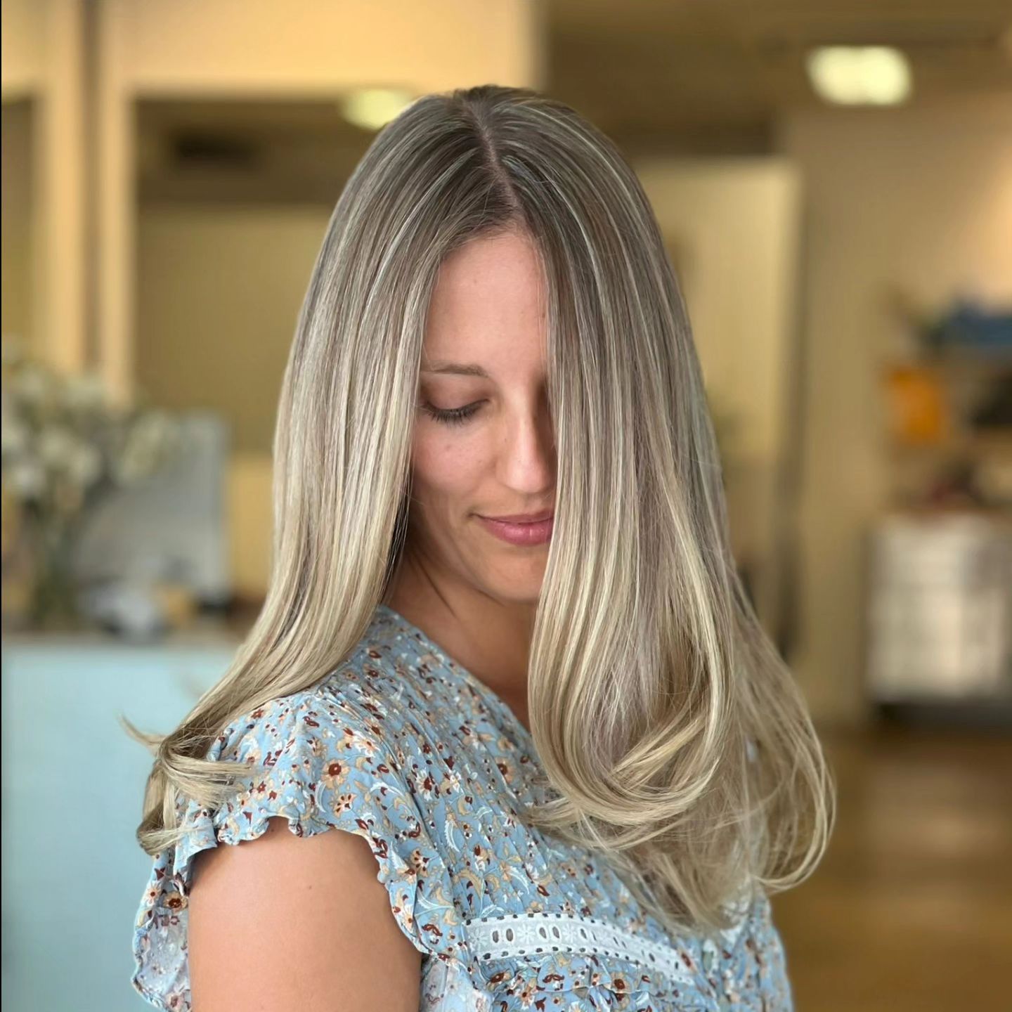 A Woman With Long Blonde Hair Is Wearing A Blue Shirt — Fuse Hair & Beauty In Darwin City, NT