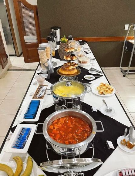 Uma mesa longa com uma variedade de comidas - Láparos hotel