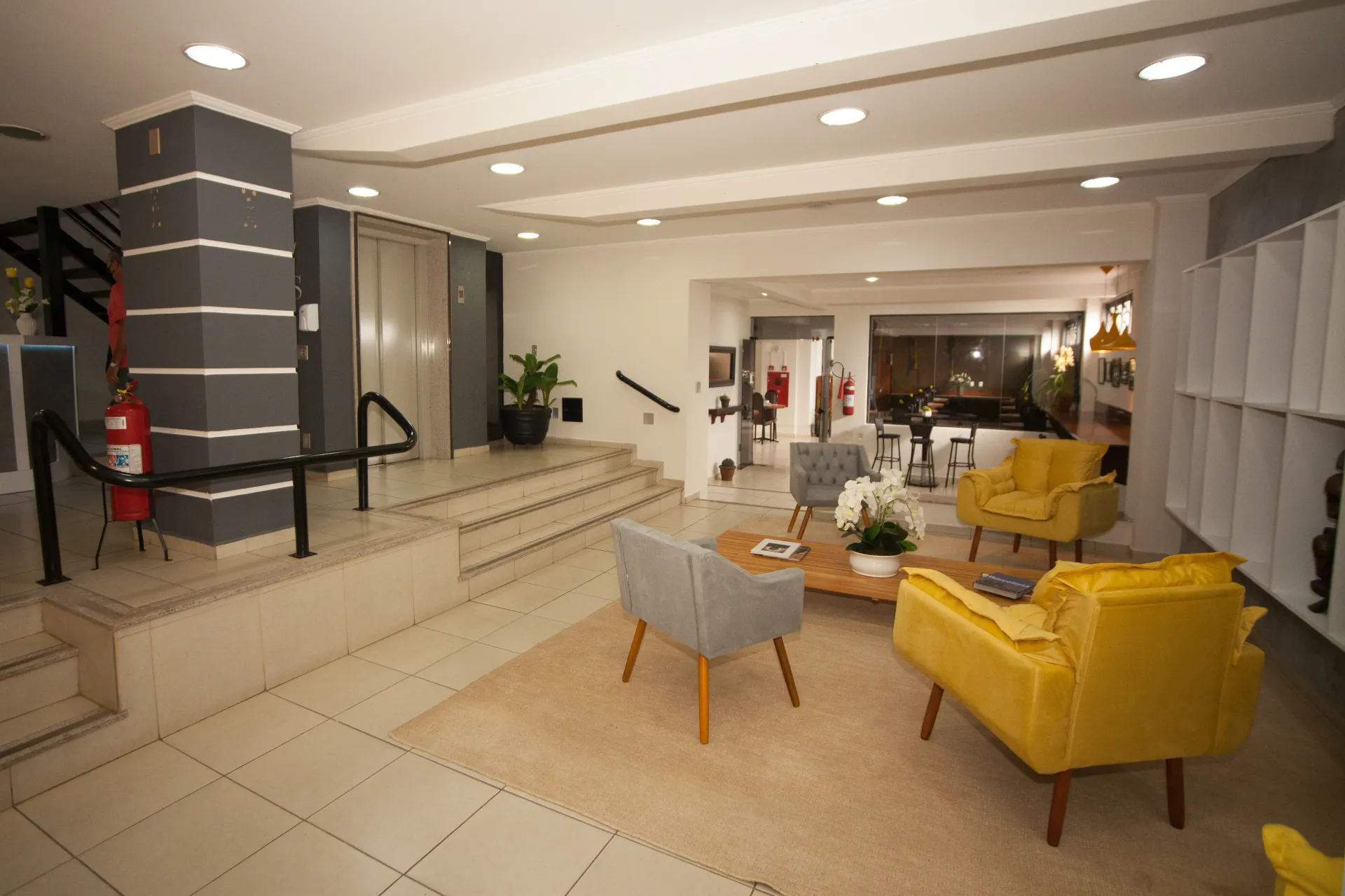 Uma sala de estar com cadeiras amarelas e uma mesa de centro - Láparos hotel