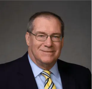A man in a suit and tie is smiling for the camera.