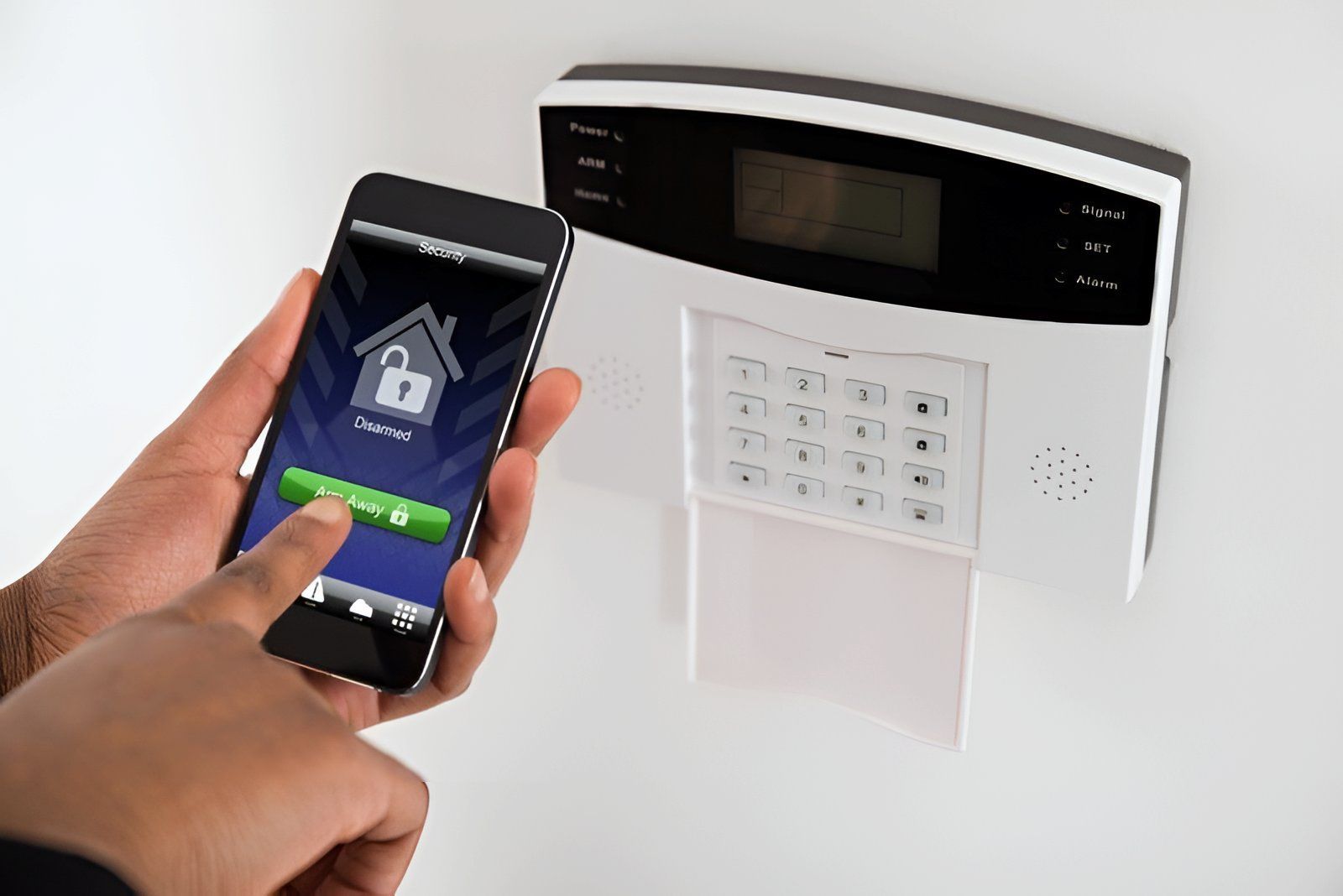 A Person is Holding a Cell Phone in Front of a Security System — Adept Security In Oak Flats, NSW