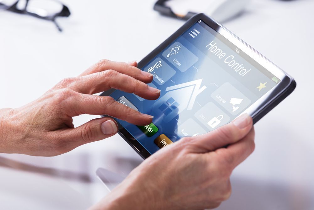A Person is Using a Tablet With a Home Control App on It — Adept Security In Albion Park, NSW